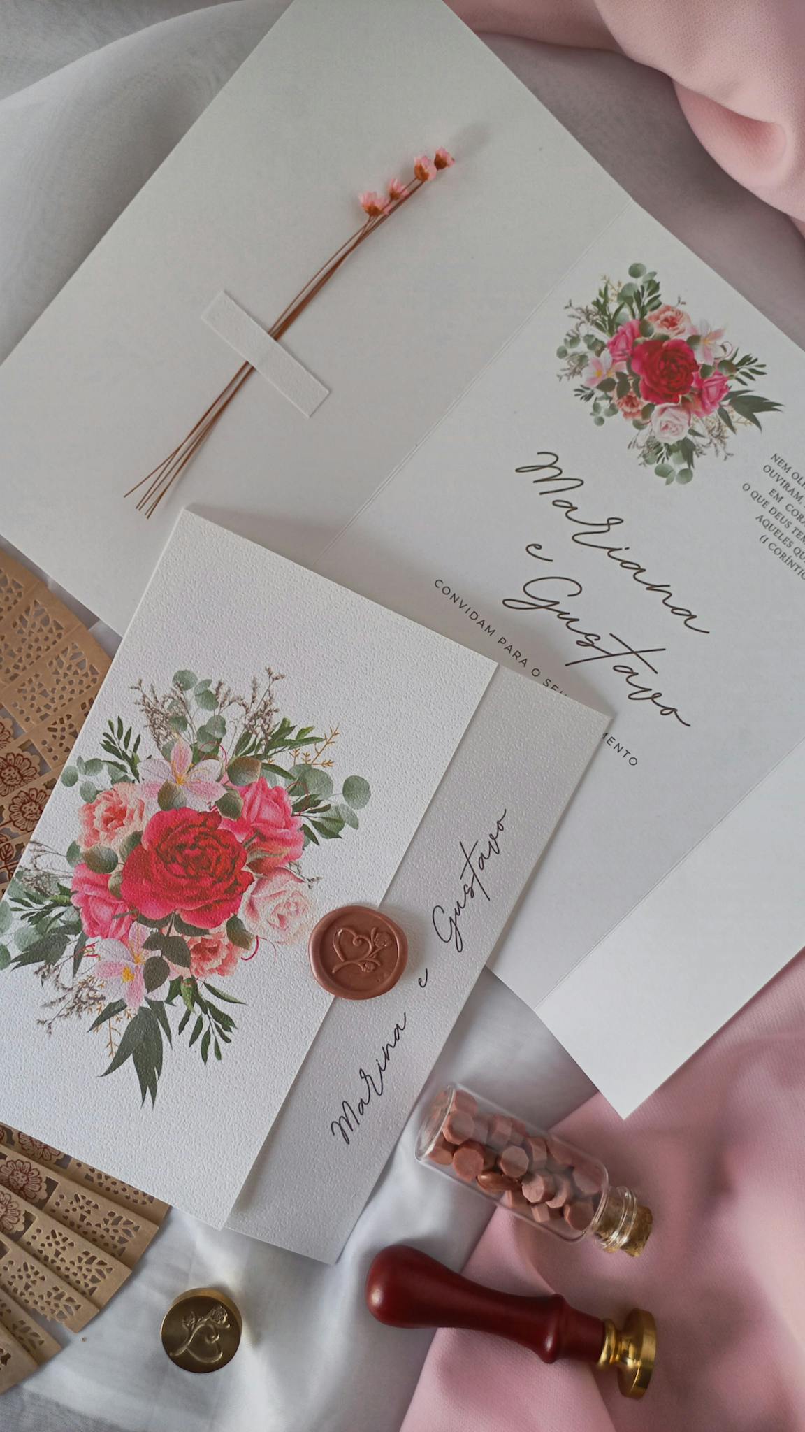 A beautifully styled wedding invitation with floral motifs and wax seal details.